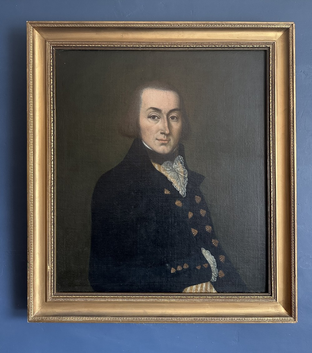 A late Georgian oil portrait of a gentleman in a dark coat with a white lace cravat set inside a giltwood frame. View II