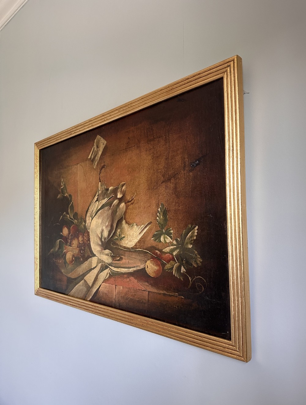A 19th-century Continental school oil painting depicting hanging game birds and fruit arranged on a stone ledge within a gilded frame. View VI
