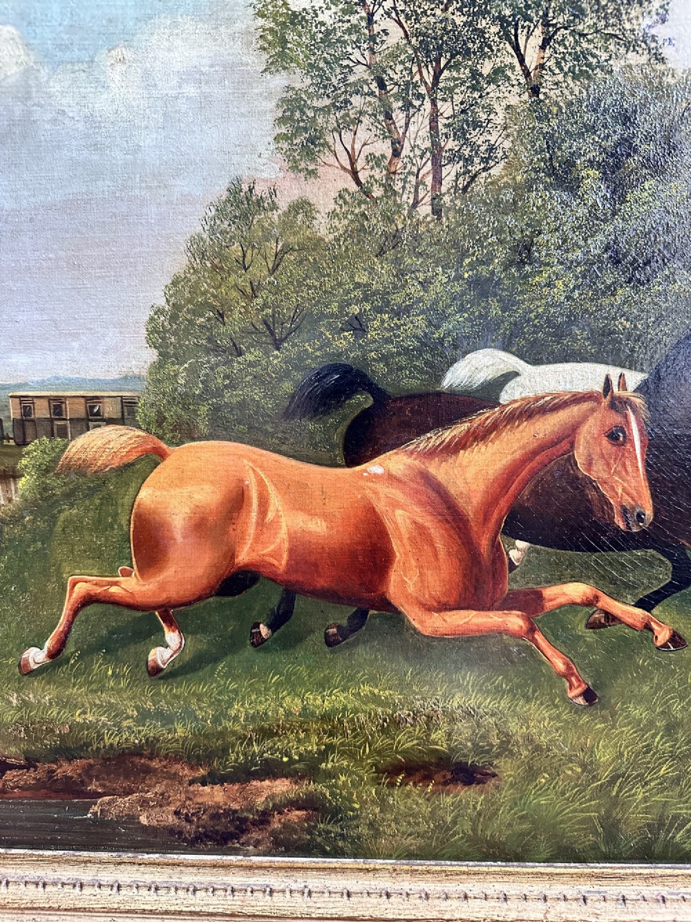 A 19th-century oil painting on canvas depicting three galloping horses in a landscape with a steam train in the background, framed in an ornate gilded wood frame. View III