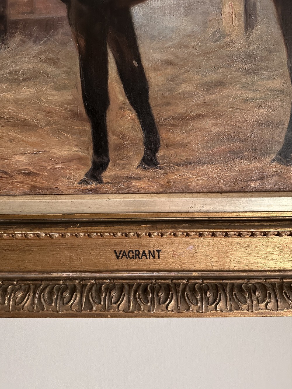 An 1896 oil painting depicting a dark brown horse standing inside a stable, housed within a gilded frame with a brass nameplate. View VI