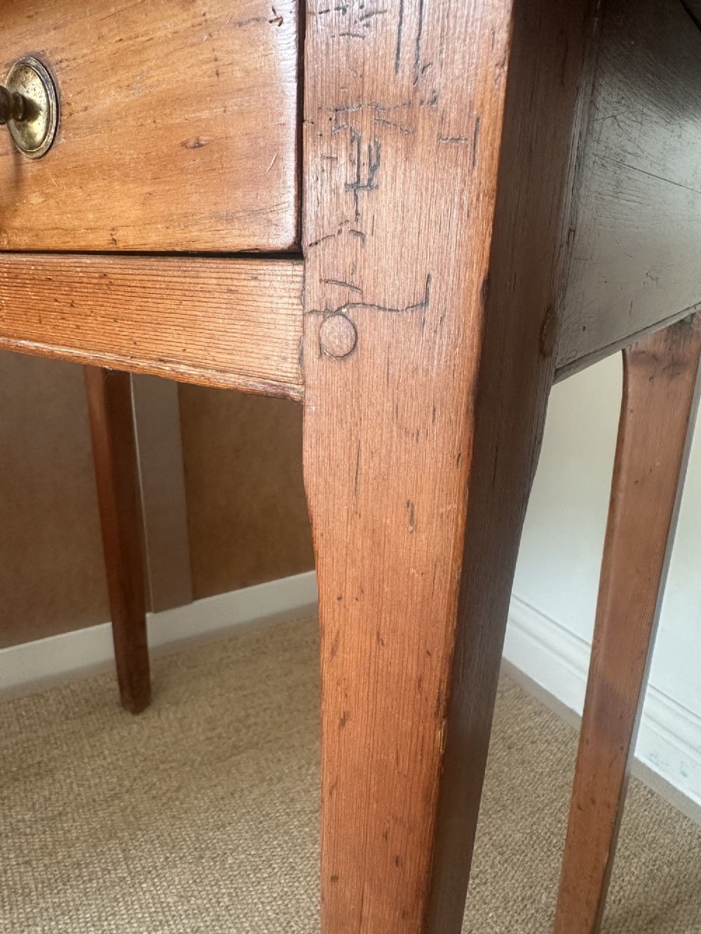 An antique pine side table featuring a single wide drawer with two brass bail handles, an overhanging rectangular top, and four square tapered legs. View V