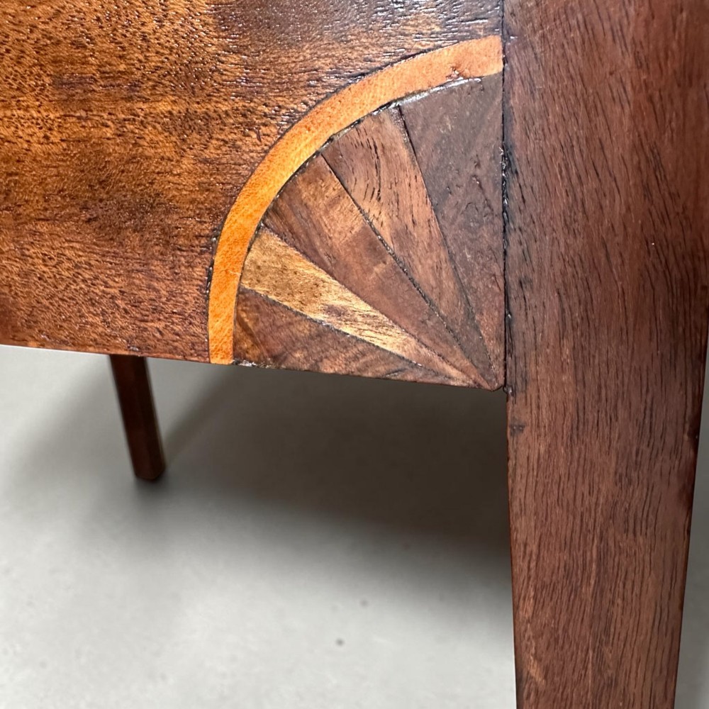 A Georgian flame mahogany bedside cabinet featuring a top drawer, central double doors, and a bottom drawer, supported by square tapered legs. View VII