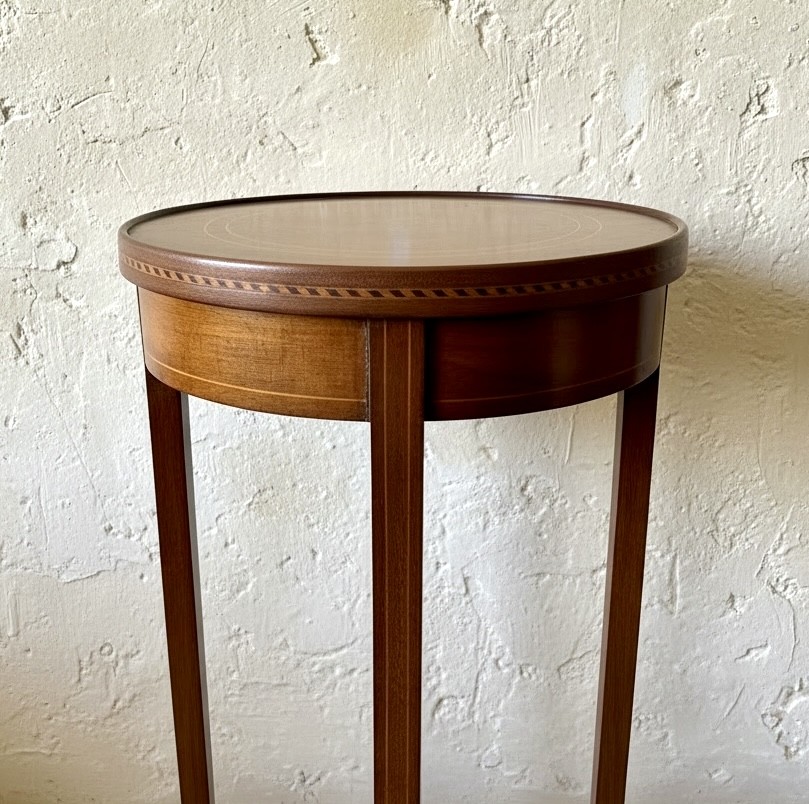 A tall, slender Edwardian mahogany plant stand featuring fine string inlay, splayed legs, and a lower circular shelf. View II