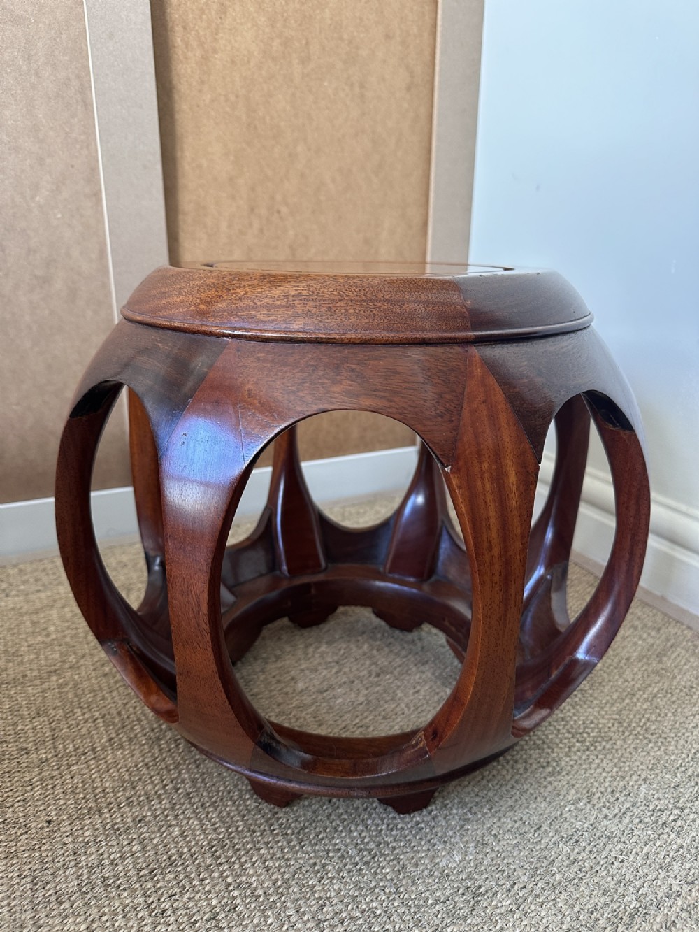 A pair of carved dark hardwood barrel stools featuring rounded openwork frames and circular burr wood inset tops. View V