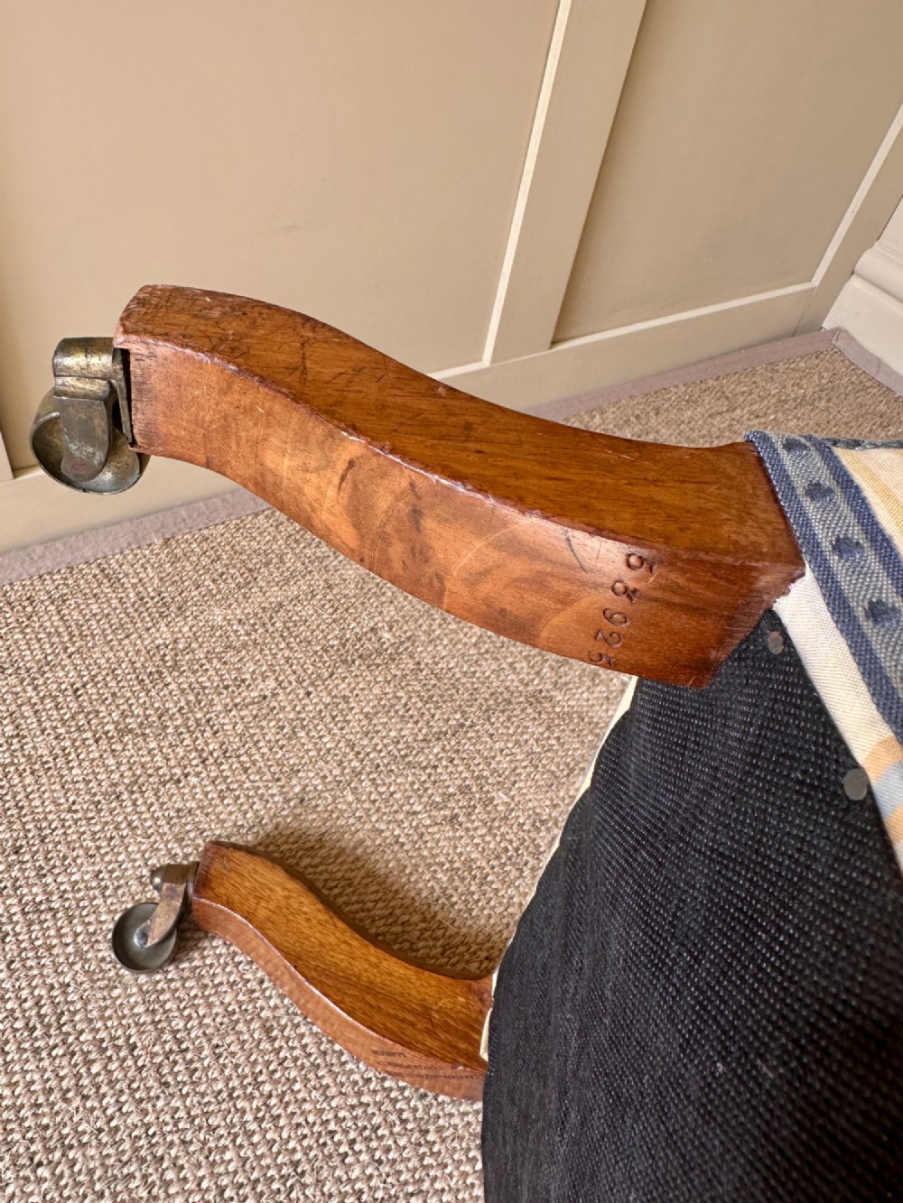 A low-seated Victorian armless slipper chair upholstered in yellow and cream tartan fabric with turned mahogany front legs on brass castors. View VII