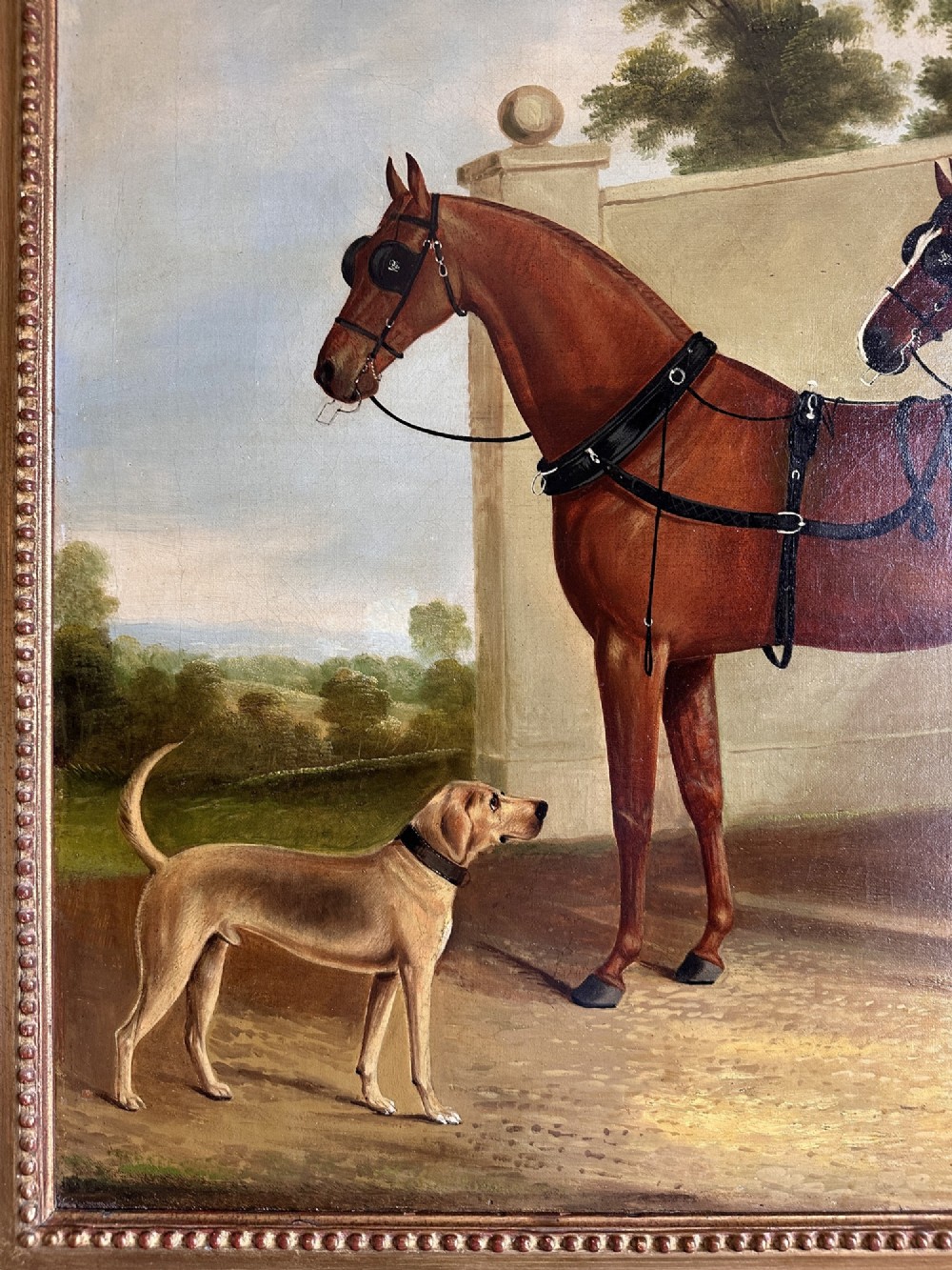 A 19th-century oil painting depicting two brown carriage horses in harness standing beside a hound, set within a beaded gilt frame. View II