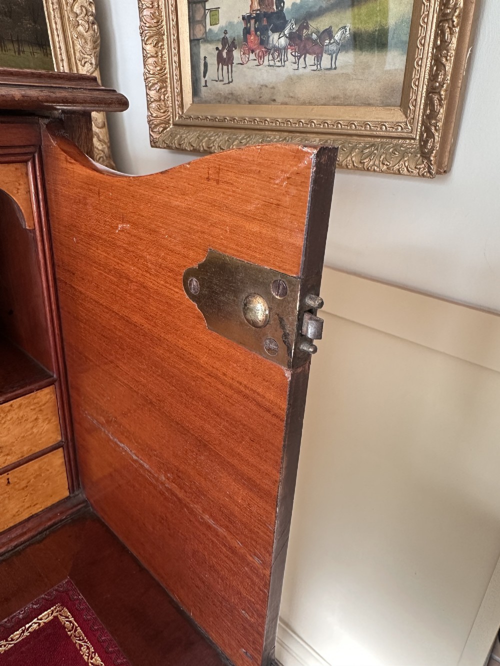 An antique nineteenth-century mahogany Wellington secretaire chest with an open drop-front writing desk section revealing internal pigeonholes above three lower drawers. View VI