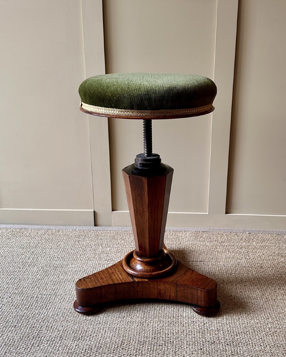 A William IV mahogany adjustable piano stool with a circular green velvet upholstered seat, supported by a faceted tapered column on a triform base. View V