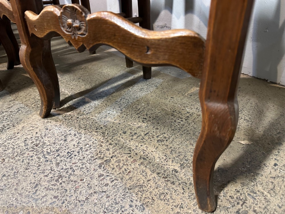 A set of twelve French provincial ladder back dining chairs featuring woven rush seats and carved timber frames. View II