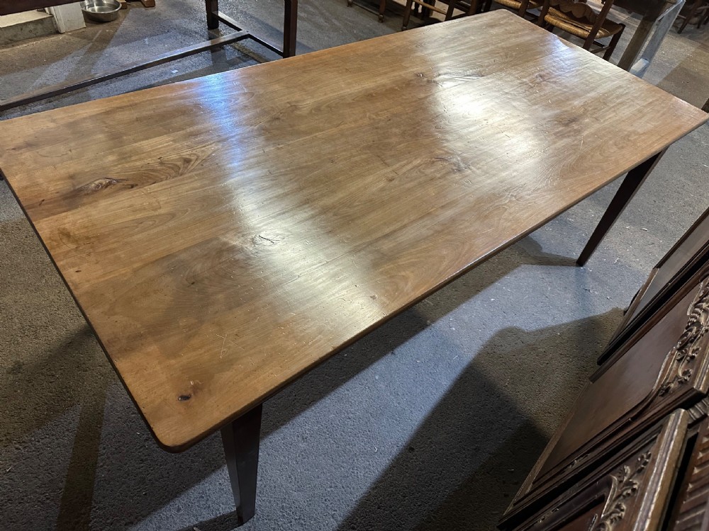 A 19th-century wide cherry wood dining table featuring a plank top, tapered square legs, and a single frieze drawer. View II