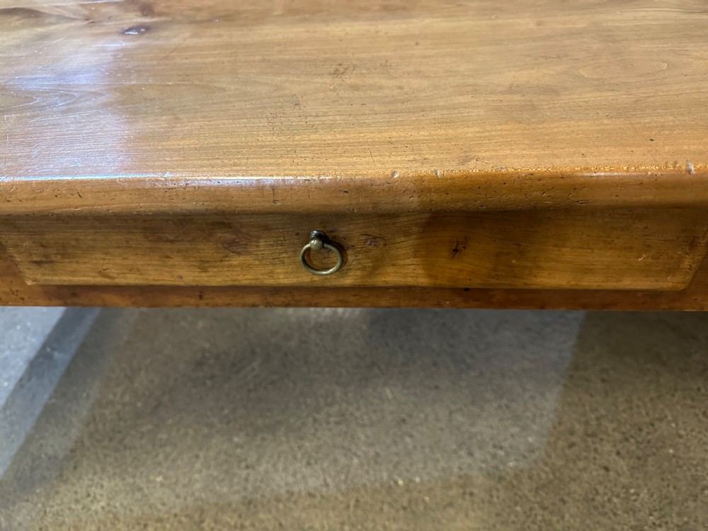 A 19th-century wide cherry wood dining table featuring a plank top, tapered square legs, and a single frieze drawer. View III