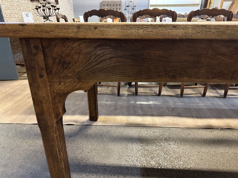 A nineteenth-century rectangular ash farmhouse dining table featuring a plank top, tapered square legs with corner brackets, and a natural aged wood grain finish. View III