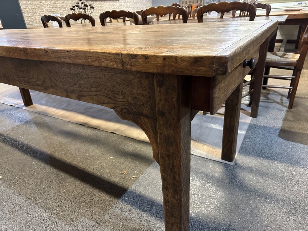 A nineteenth-century rectangular ash farmhouse dining table featuring a plank top, tapered square legs with corner brackets, and a natural aged wood grain finish. View IV