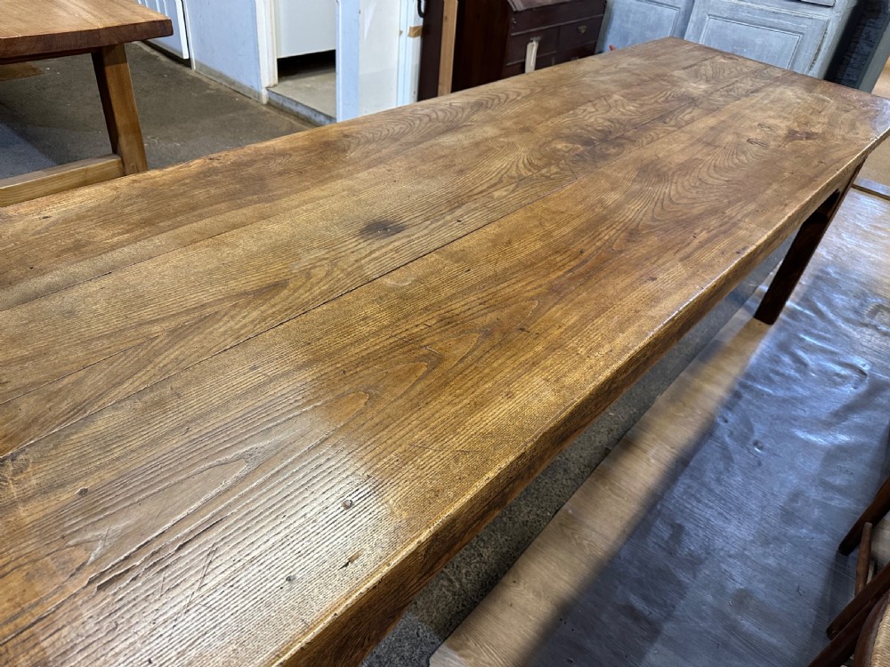 A nineteenth-century rectangular ash farmhouse dining table featuring a plank top, tapered square legs with corner brackets, and a natural aged wood grain finish. View VI