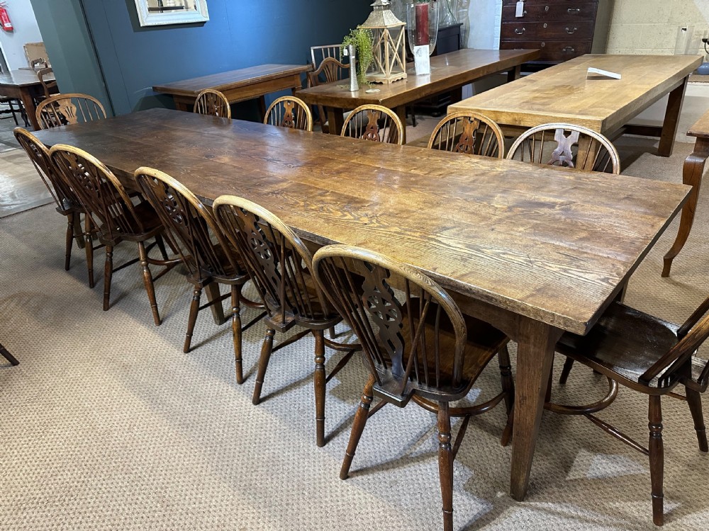 A large rectangular wooden dining table featuring a weathered grain top and tapered legs. View III