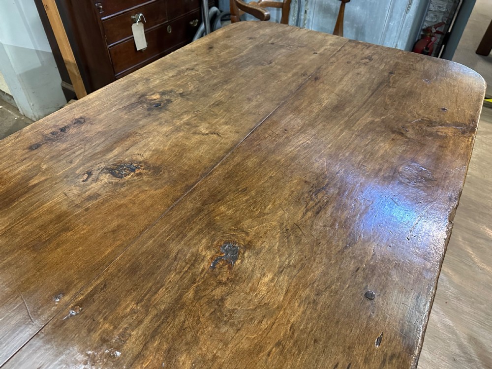 An early 19th-century rectangular dining table made from beech wood featuring a two-plank top with rounded corners and four tapered square legs. View II