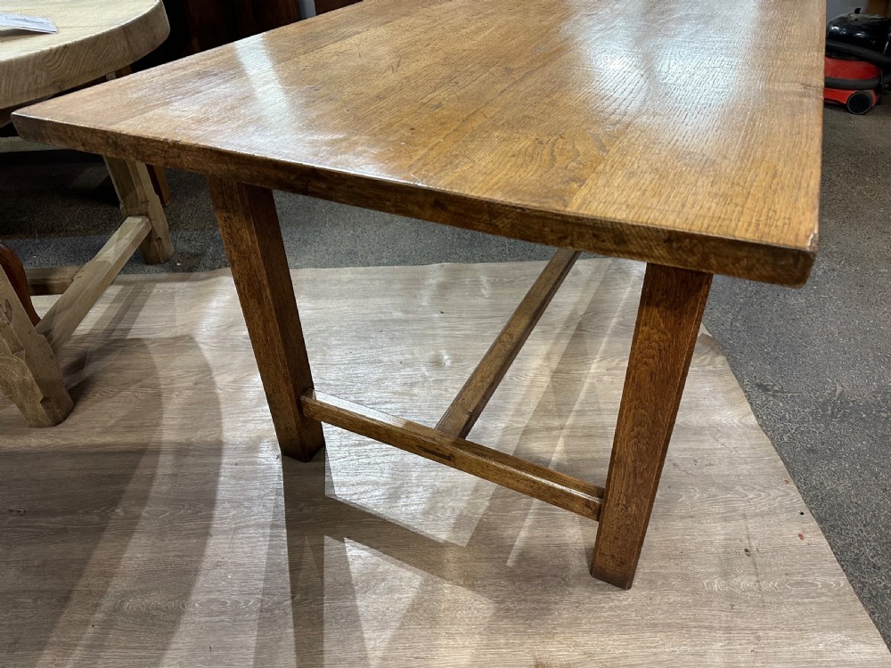 A long rectangular antique oak farmhouse dining table featuring a plank top and an H-stretcher base structure. View II