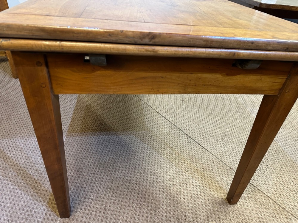 A 19th-century French provincial cherrywood dining table featuring a double draw-leaf mechanism and four square tapered legs. View IV