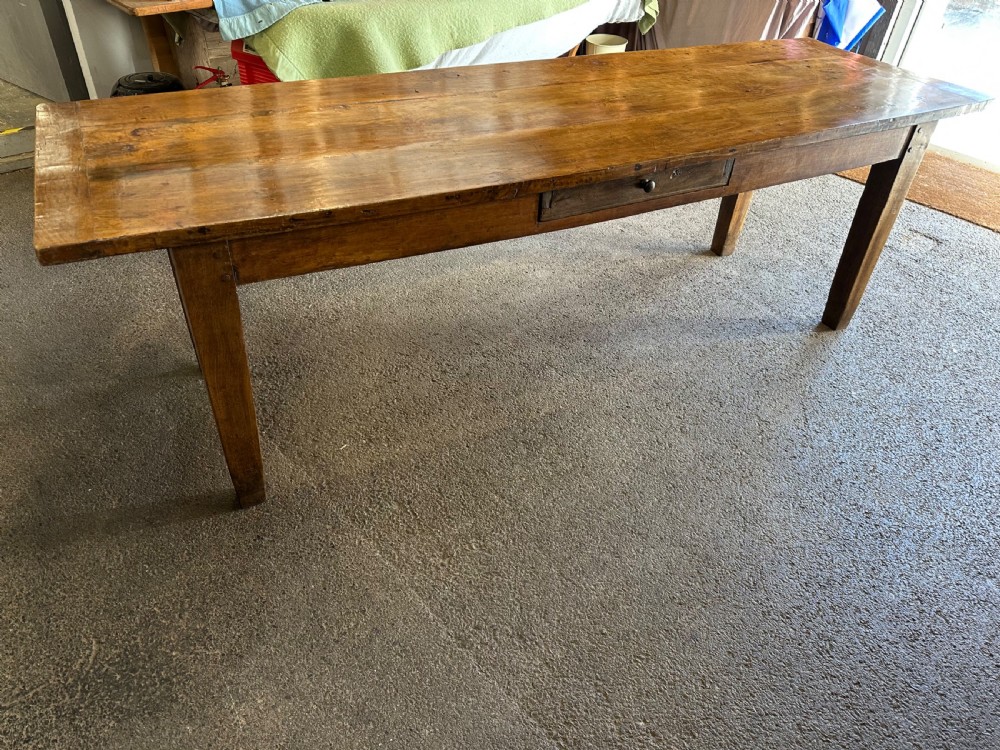 A nineteenth-century rectangular beech farmhouse dining table featuring a patinated wood top, a single side drawer with a small pull handle, and tapered wooden legs. View II