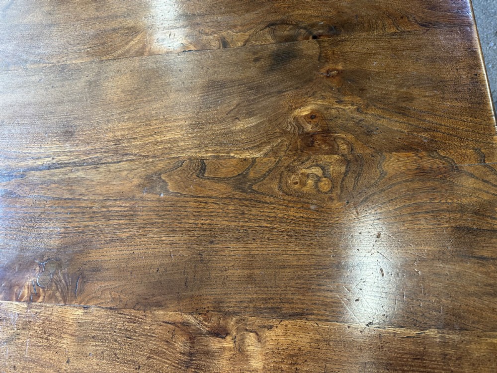 A long rectangular antique elm dining table featuring turned wooden legs connected by a central stretcher base and a smooth timber top. View IV