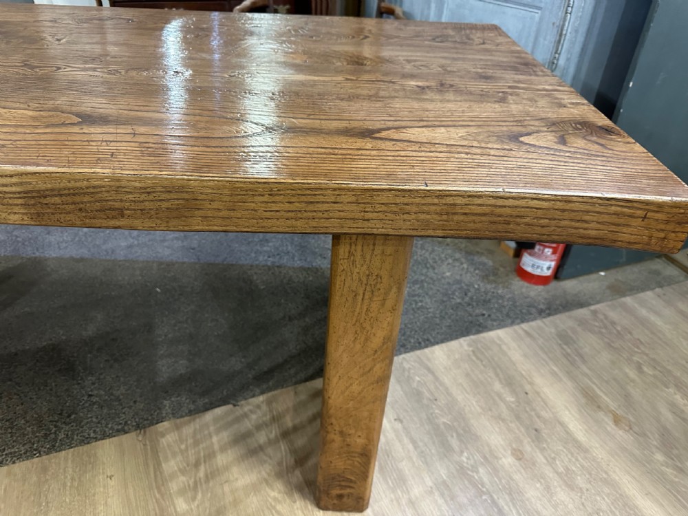 A rectangular antique solid ash dining table featuring a prominent wood grain top and sturdy square legs joined by low end stretchers. View III