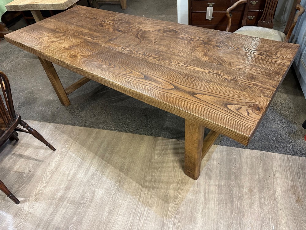 A rectangular antique solid ash dining table featuring a prominent wood grain top and sturdy square legs joined by low end stretchers. View VI