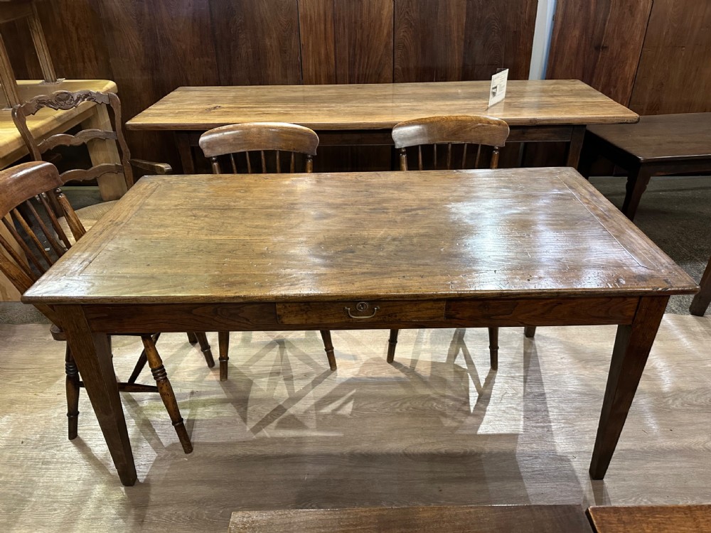 A 19th-century rectangular chestnut farmhouse table featuring a framed timber top, a single central frieze drawer, and four tapered square legs.