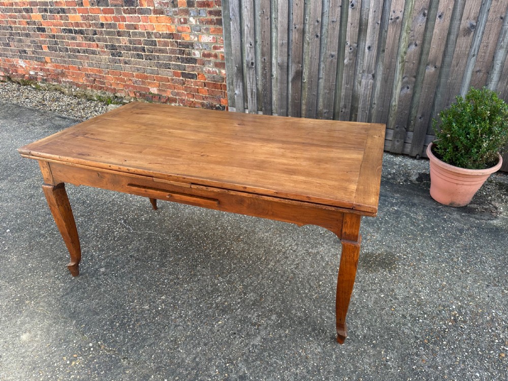 An antique cherry wood extending dining table with double draw-leaves, an integrated pull-out bread slide, and slender cabriole legs. View VI