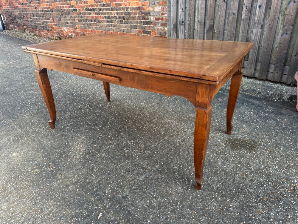 An antique cherry wood extending dining table with double draw-leaves, an integrated pull-out bread slide, and slender cabriole legs. View VII