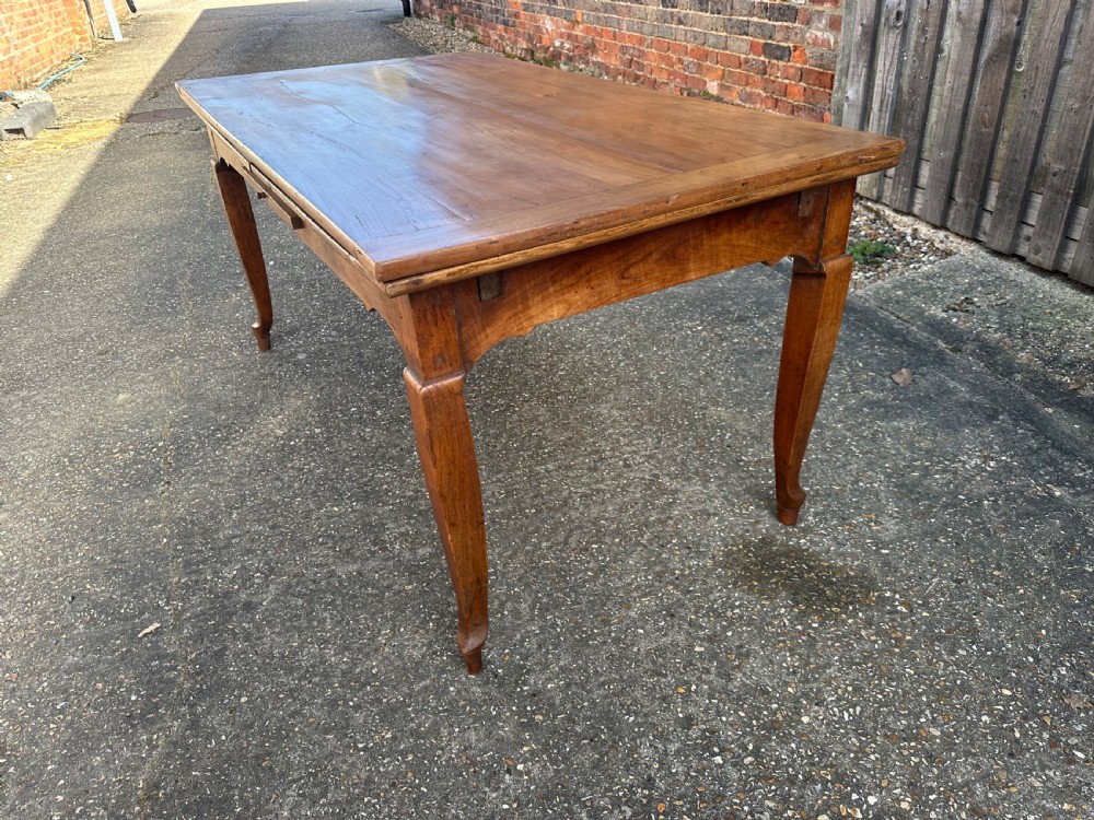 An antique cherry wood extending dining table with double draw-leaves, an integrated pull-out bread slide, and slender cabriole legs. View VIII