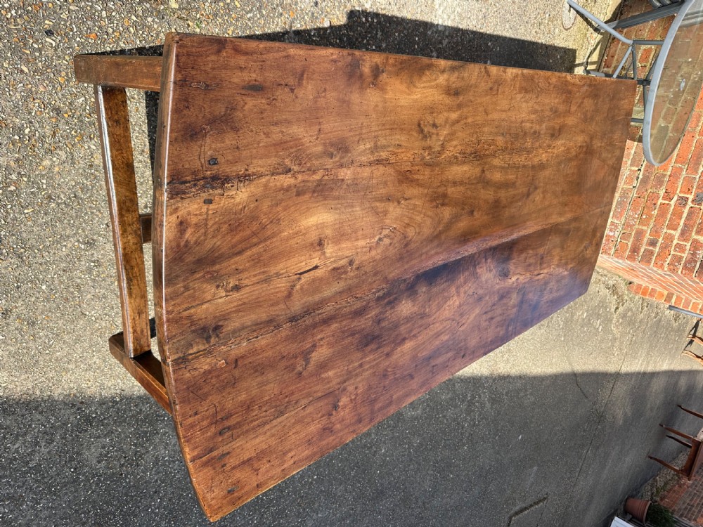 An early nineteenth-century solid walnut dining table featuring a wide plank top with natural patina and square legs linked by low stretchers. View III