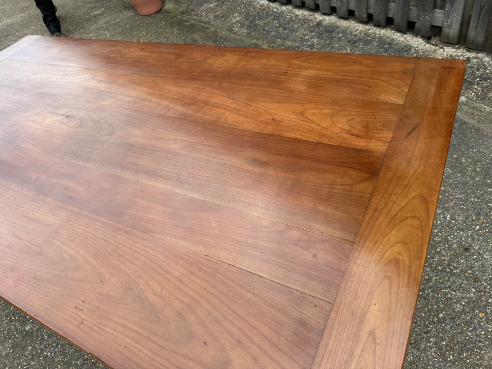 A 19th-century cherry wood extending dining table featuring turned legs and side extension leaves on a plain background. View IV