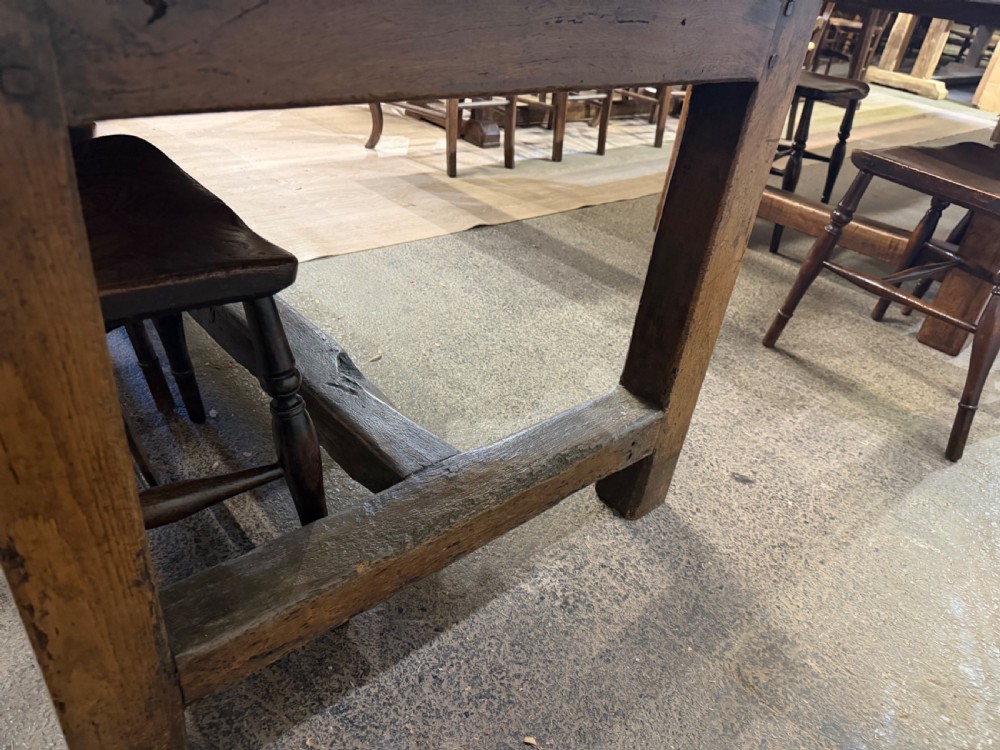 A long late 18th-century oak and beech farmhouse dining table featuring a plank top and squared legs joined by stretchers. View V