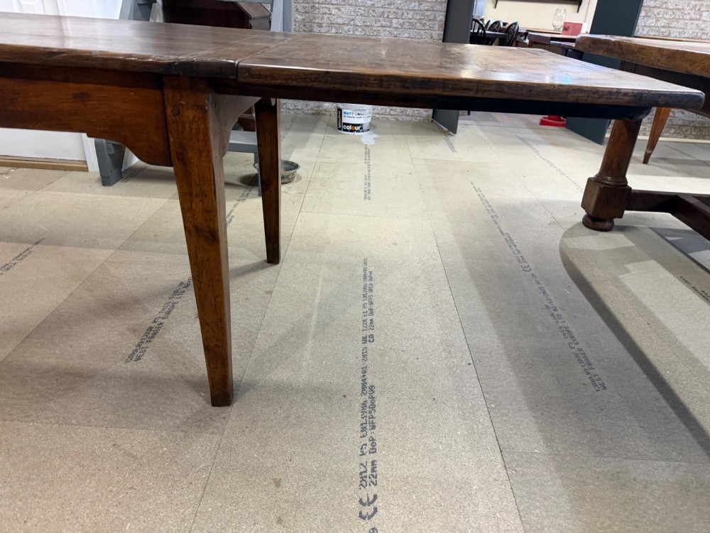 A long antique oak extending dining table featuring two end extension leaves, side frieze drawers, and tapered square legs. View III