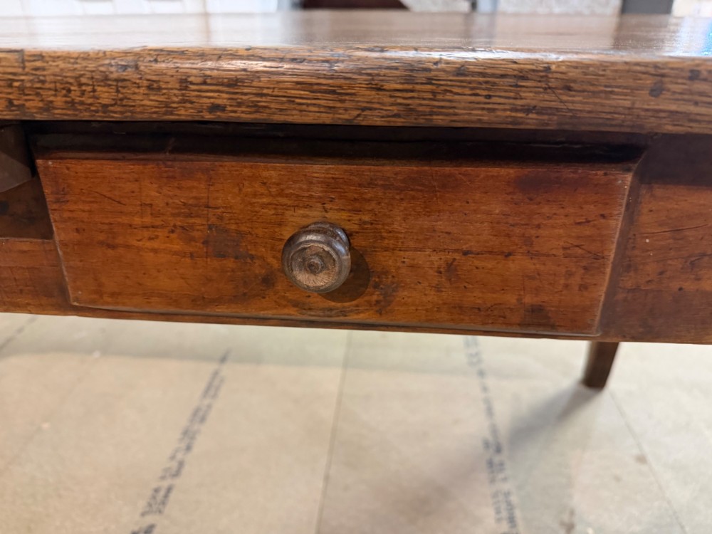 A long antique oak extending dining table featuring two end extension leaves, side frieze drawers, and tapered square legs. View V