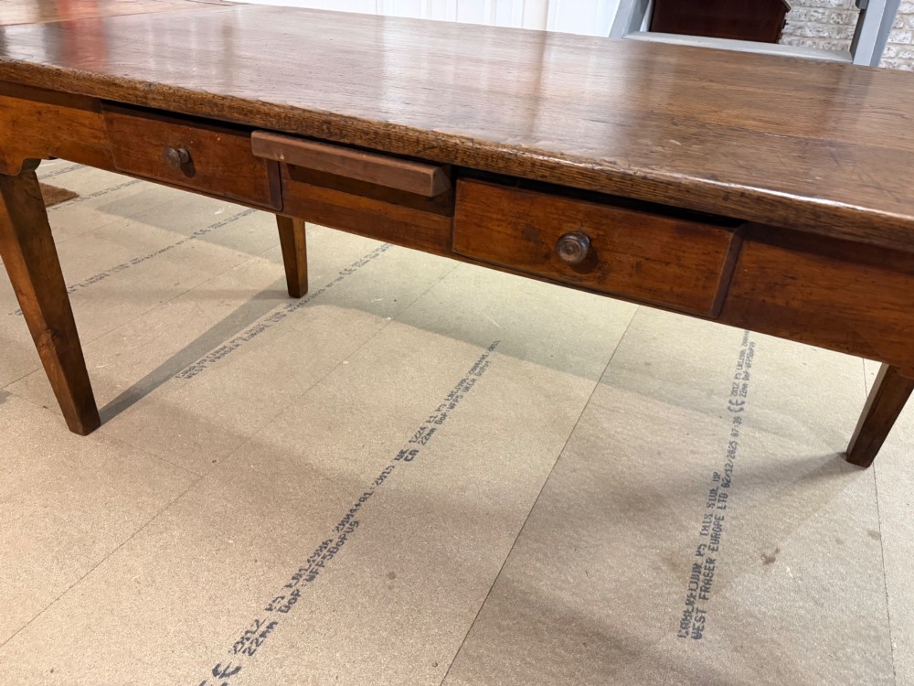 A long antique oak extending dining table featuring two end extension leaves, side frieze drawers, and tapered square legs. View VII