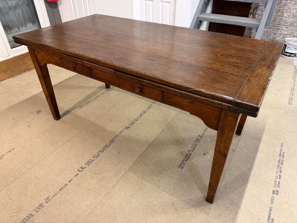 A long antique oak extending dining table featuring two end extension leaves, side frieze drawers, and tapered square legs. View IX