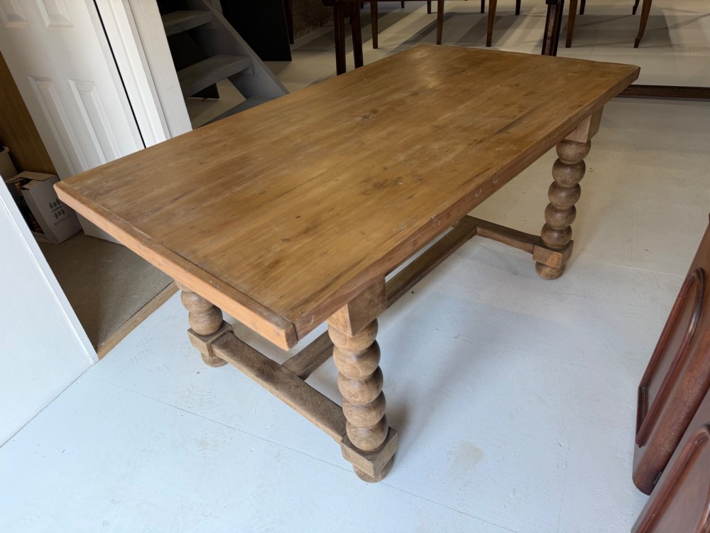 A pale oak and beech rectangular table featuring distinct bobbin-turned legs and lower support stretchers.