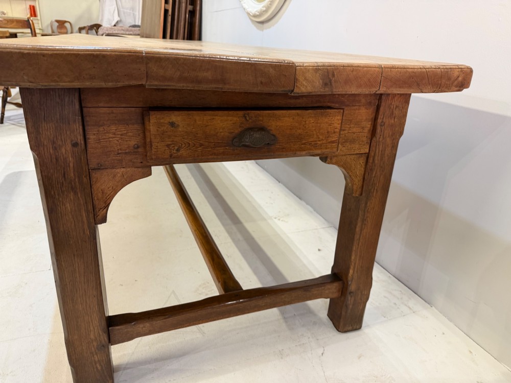 A 19th-century French beech farmhouse dining table with a light timber plank top and dark wooden frame supported by an H-stretcher. View II