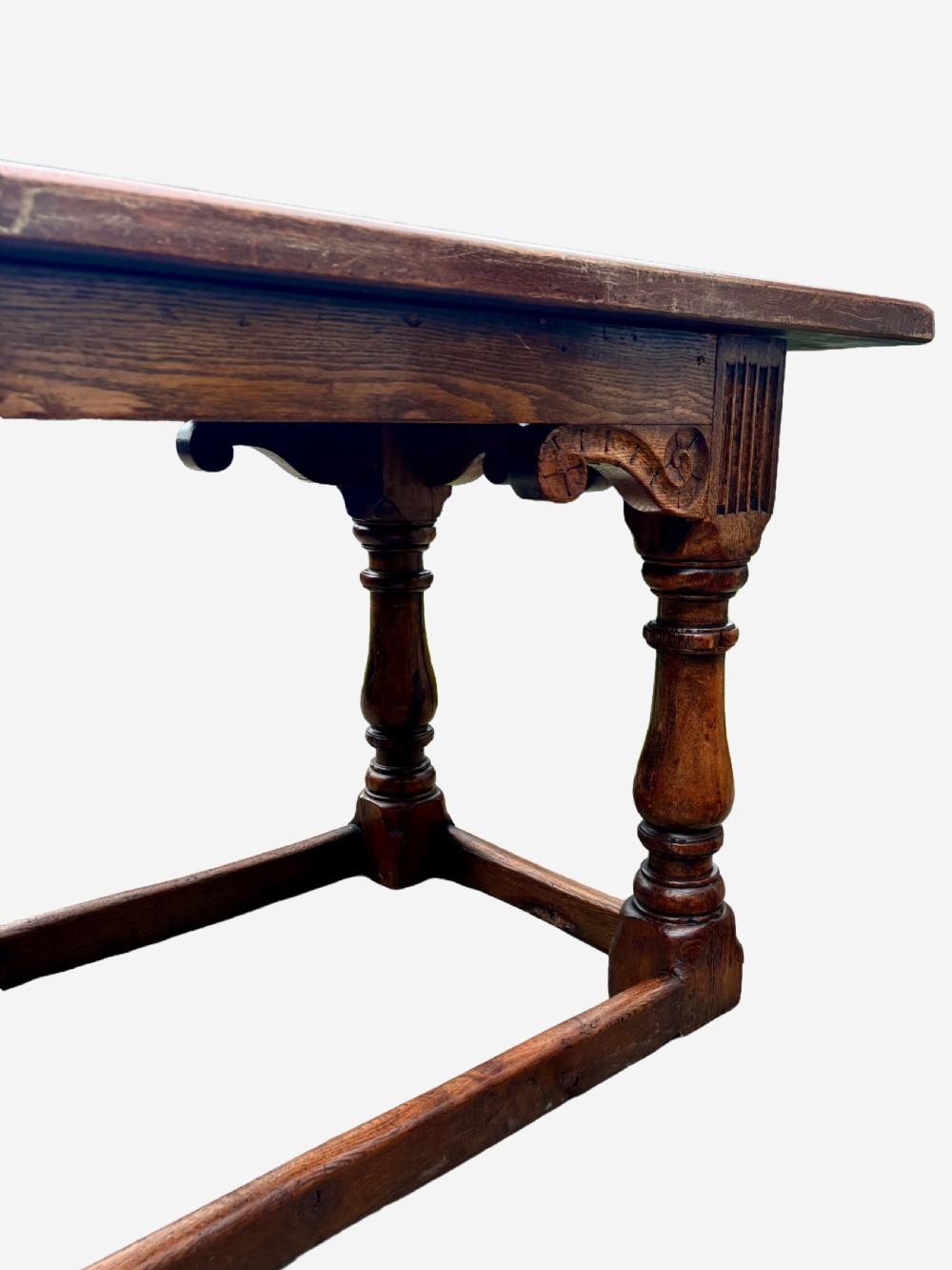 A mid-Victorian solid oak refectory table featuring turned baluster legs, a carved frieze, and a low perimeter stretcher. View IV
