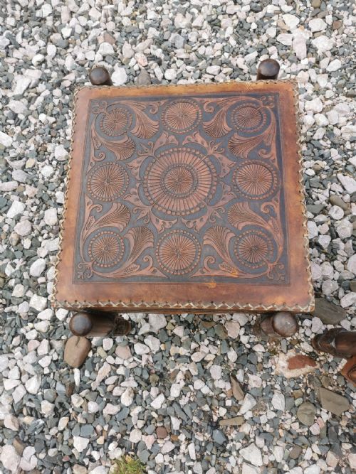 A LARGE PAIR OF ANTIQUE EASTERN EMBOSSED AND DECORATED LEATHER AND WALNUT FRAMED STOOLS - ADDITIONAL PHOTO 2
