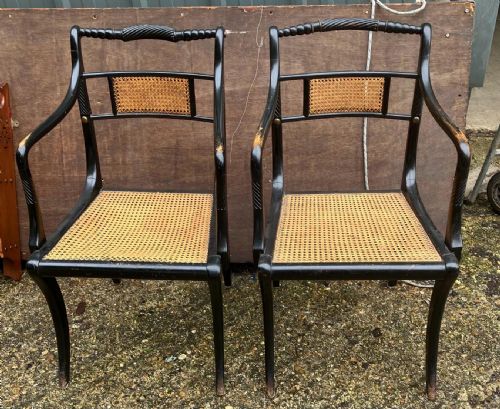an antique pair of ebonised and cane elbow chairsin the regency style - CATEGORY: ANTIQUE CHAIRS - DATED 1900