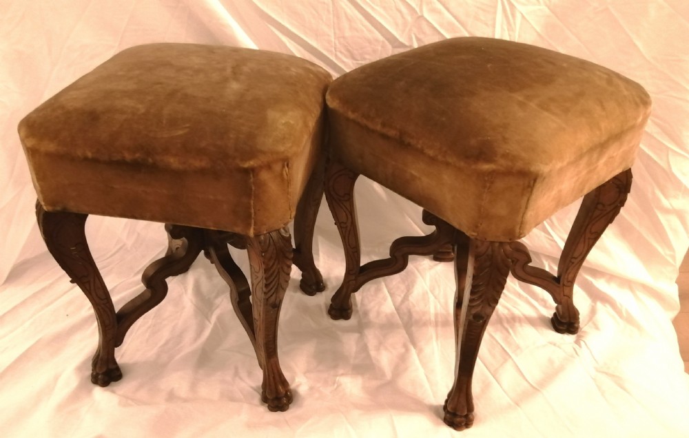 An antique pair of French carved walnut stools.