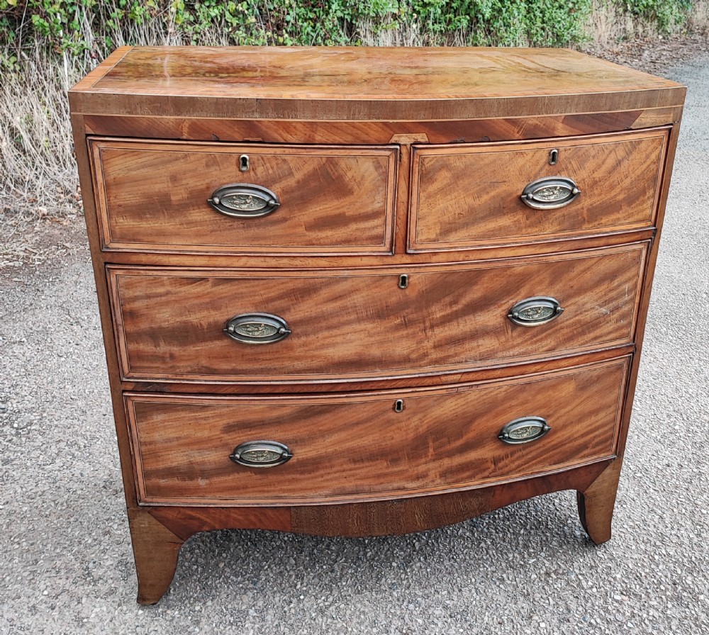 An antique regency inlaid bow front chest 