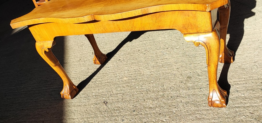 An antique walnut coffee table featuring a serpentine-shaped top with figured grain, supported by four cabriole legs ending in carved ball and claw feet. View VIII