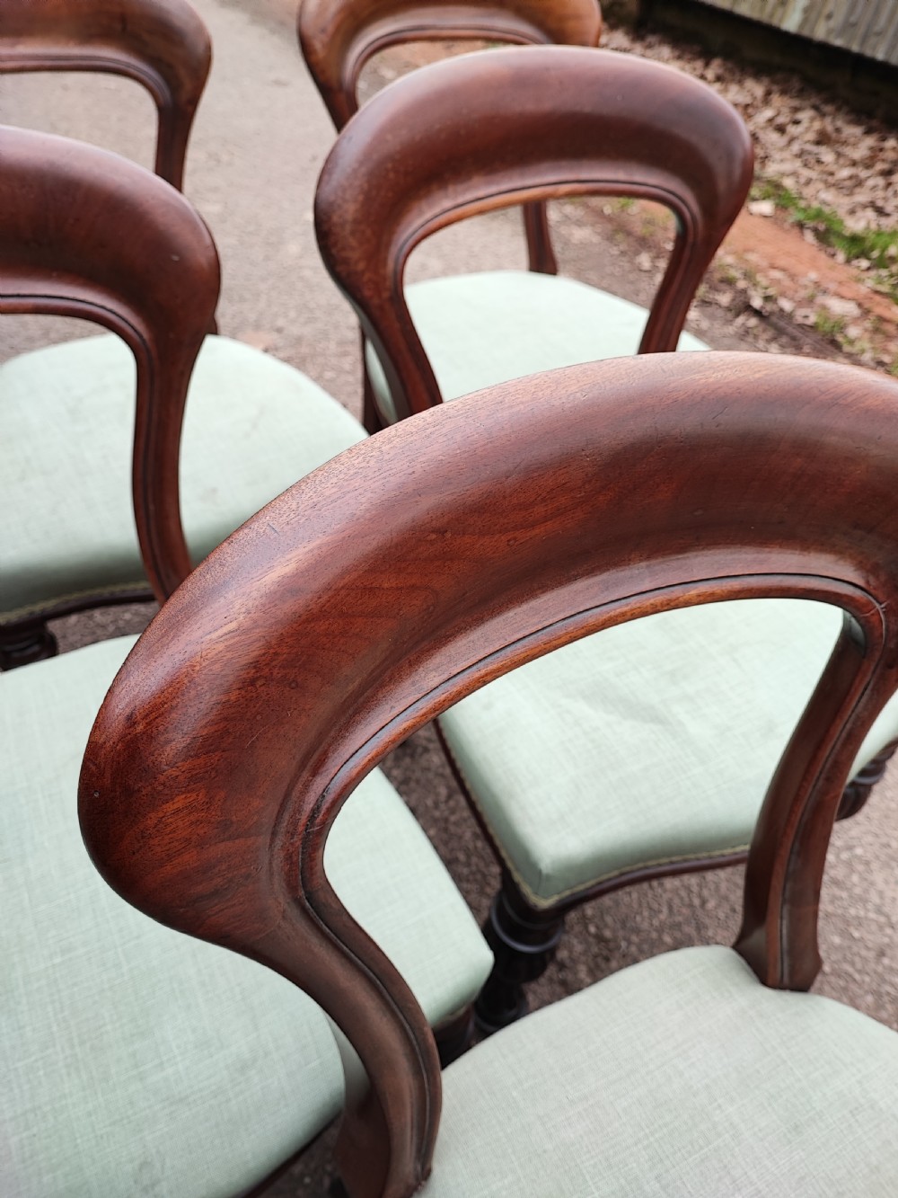A set of six Victorian balloon back dining chairs made of dark mahogany wood with soft green upholstered seats. View V