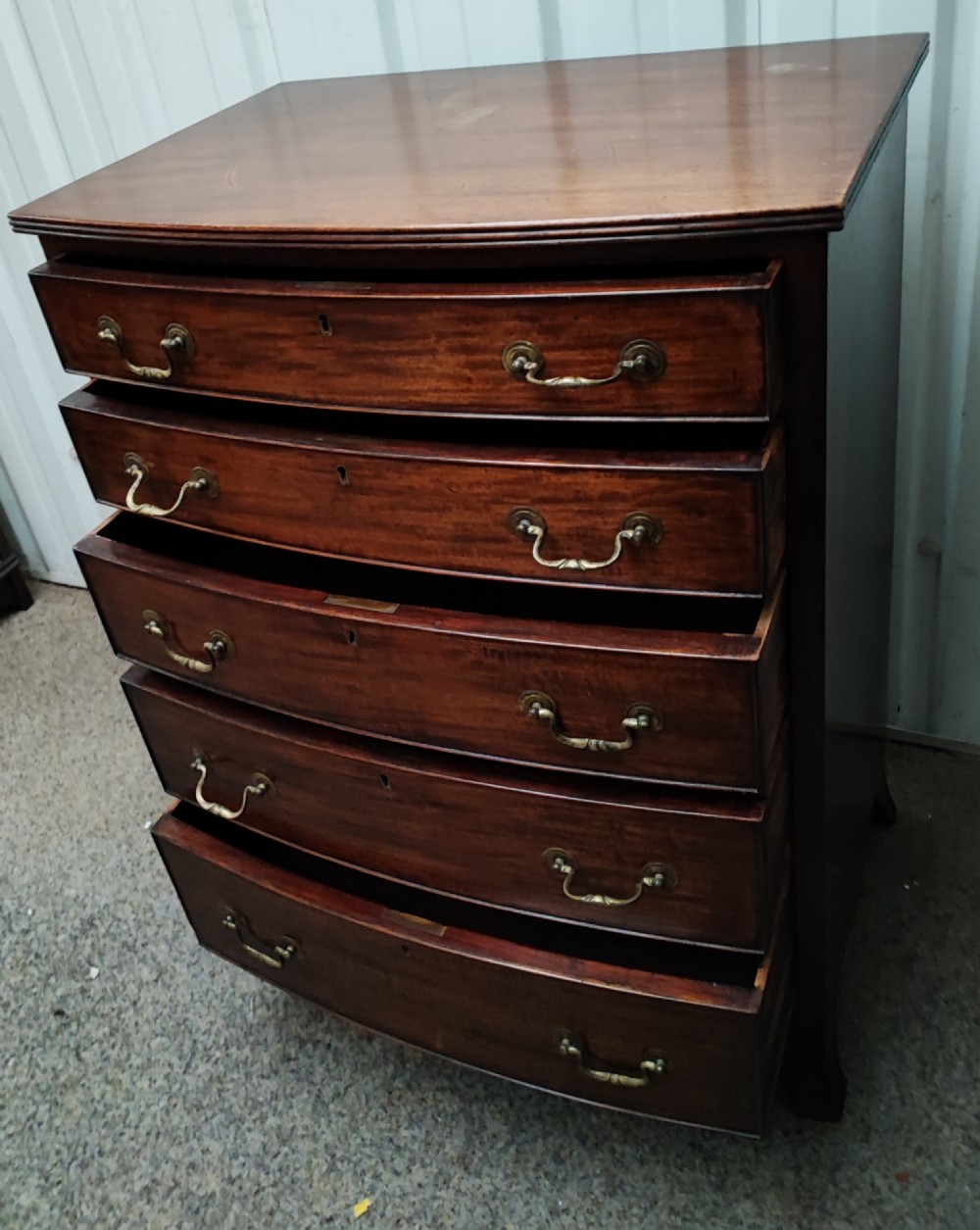 An antique mahogany bow front chest of drawers. View IV