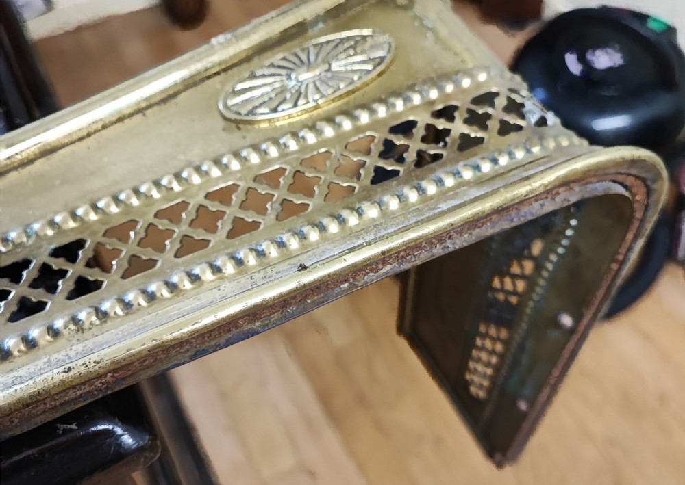 A long Victorian polished brass fireplace fender featuring a pierced lattice panel with beaded borders and oval engraved motifs. View II