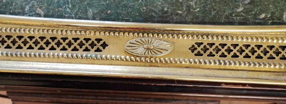A long Victorian polished brass fireplace fender featuring a pierced lattice panel with beaded borders and oval engraved motifs. View VI