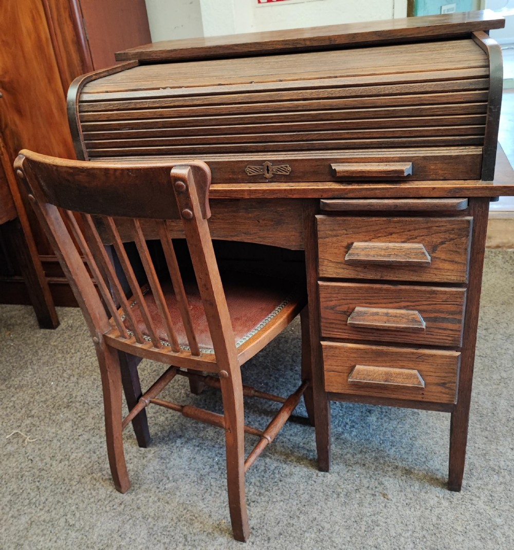 An antique oak roll top desk and chair 